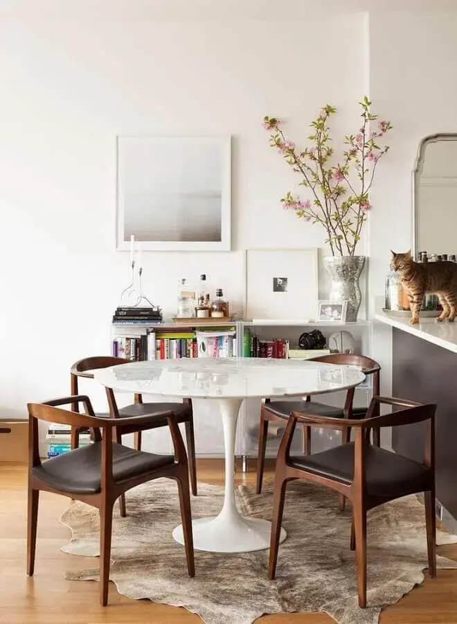 decoração clean para sala de jantar com mesa redonda e cadeira com braço Foto Constance Zahn