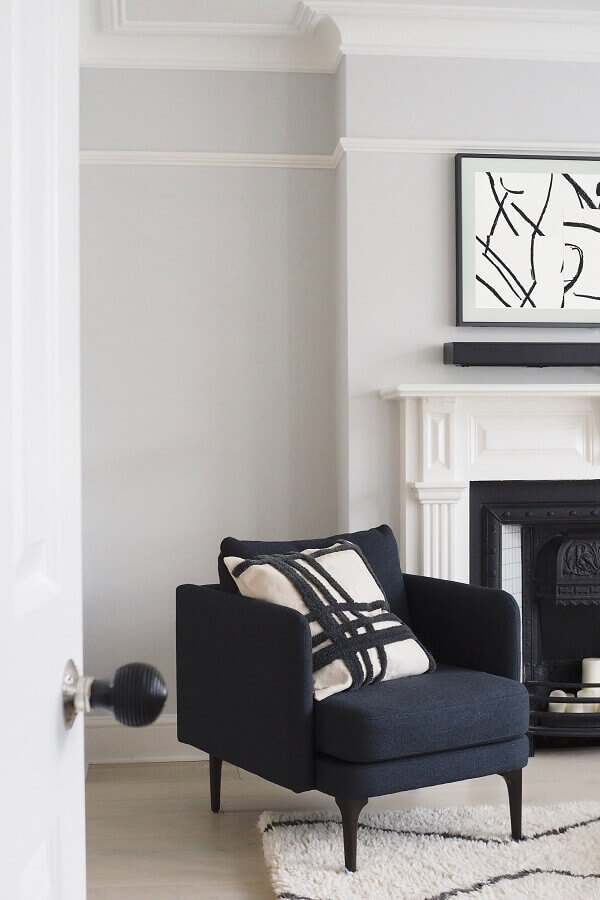 decoração de sala branca com poltrona pequena e confortável preta Foto Archello