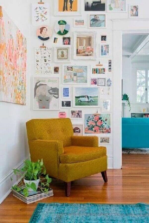 decoração simples com poltrona pequena para sala com parede de quadros Foto Iaza