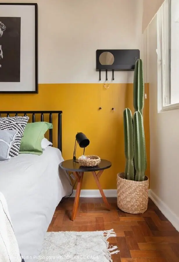 quarto decorado com vaso de chão e meia parede amarela Foto Histórias de Casa