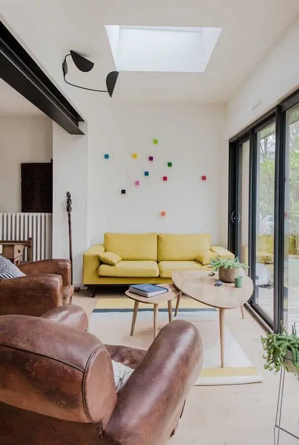 sala de visita simples decorada com sofá amarelo e poltronas de couro Foto Pinterest