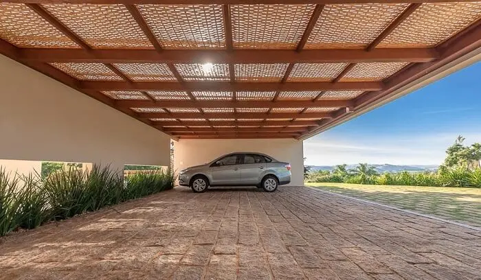 A cobertura de madeira para garagem com acabamento em tela chama a atenção no imóvel. Fonte: Pinterest