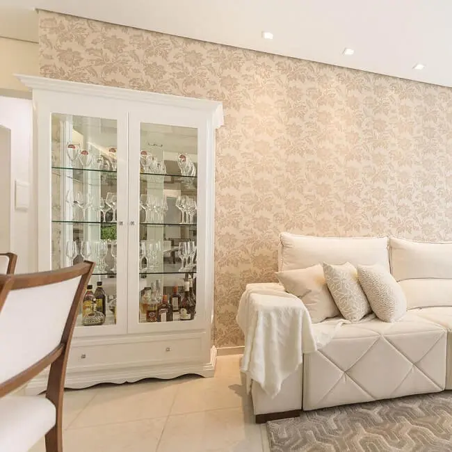 A cristaleira de madeira branca se conecta com a decoração da sala de estar e jantar. Fonte: A2 Arquitetura