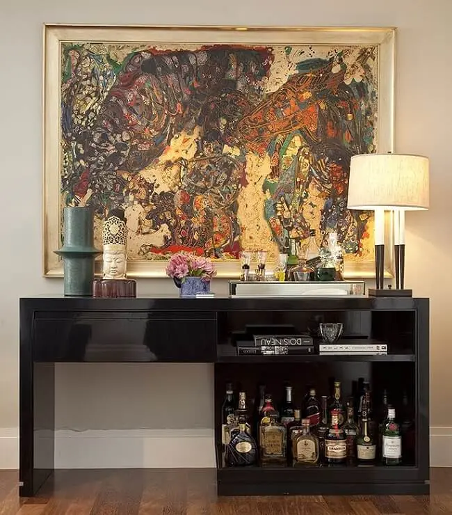 Aparador preto laqueado assume a função de bar na sala de estar. Projeto de Fernando Piva
