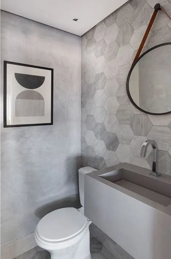 Banheiro com pia de granito cinza esculpida e decoração moderna