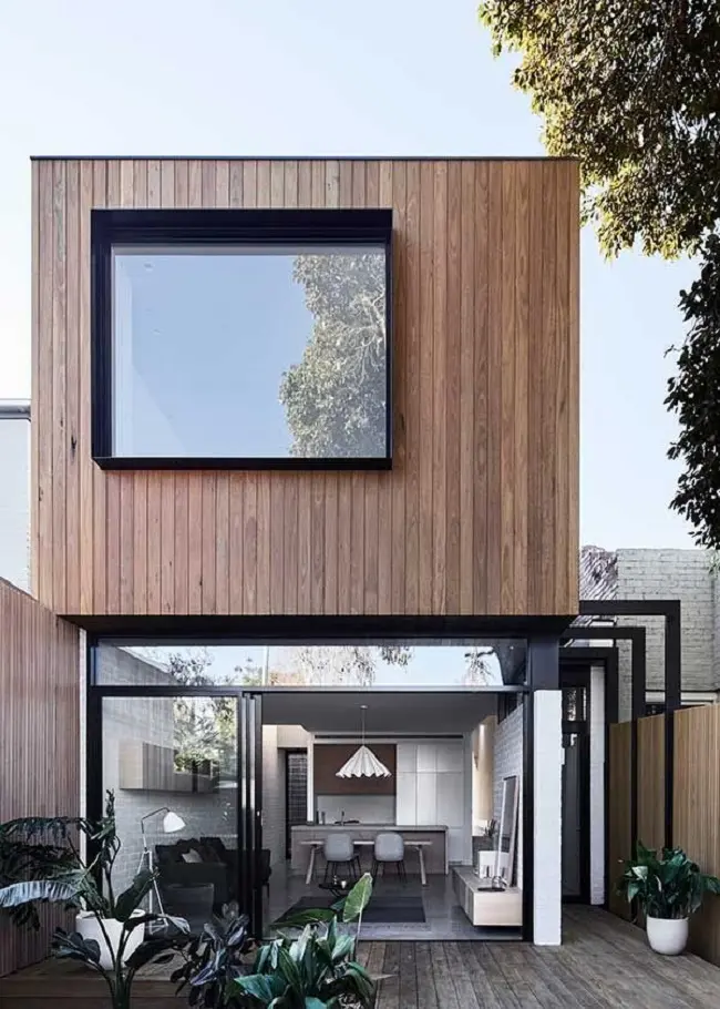 Casa moderna com revestimento externo metálico, madeira e janela ampla de vidro. Fonte: Revista Viva Decora 2