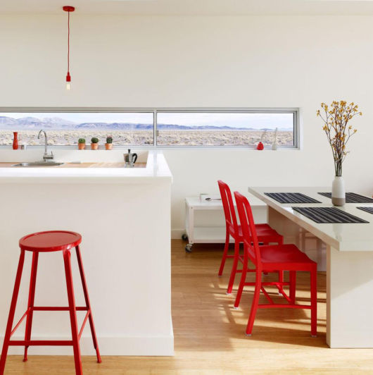 Cozinha americana branca com cadeira vermelha