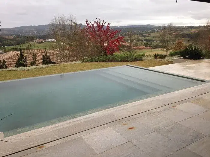 Decore sua área externa com piscina grande com prainha e borda infinita. Projeto por Alalou Paisagismo