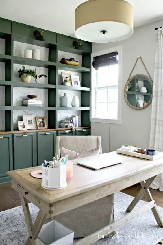 Escritório com armário verde e mesa de madeira