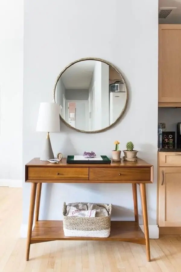 Espelho redondo e aparador para sala pé palito decoram o cômodo. Fonte: Pinterest