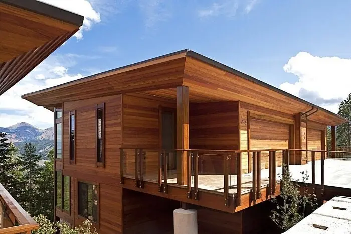 Casa de madeira com sacada com guarda corpo de vidro 