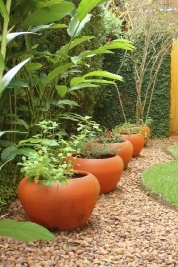 Jardim decorado com pedras ajuda a delimitar o espaço dos vasos de plantas. Fonte: Pinterest