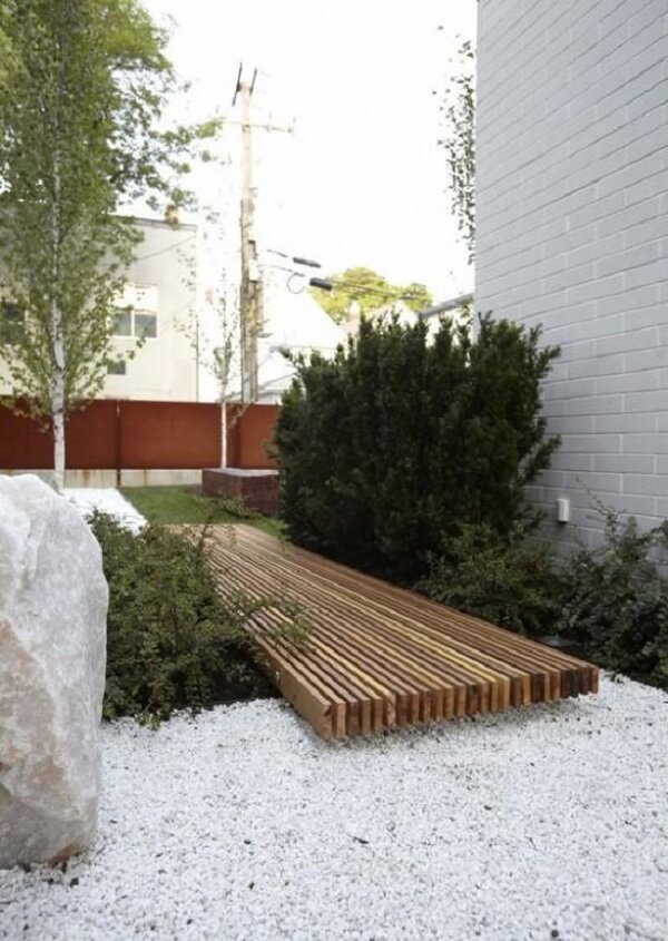 Jardim simples com pedras brancas e deck de madeira. Fonte: Pinterest