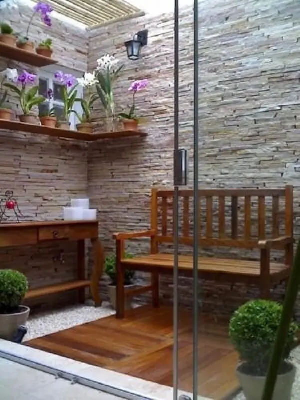 Jardim simples com pedras brancas e prateleiras com orquídeas. Fonte: Pinterest