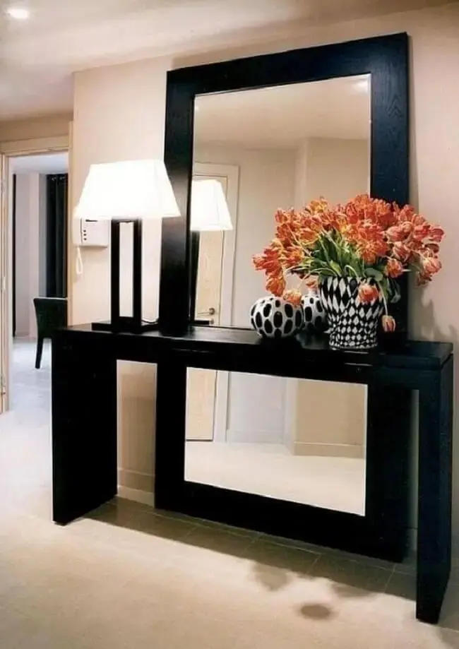 O aparador preto com espelho de chão traz sofisticação para o décor. Fonte: Pinterest