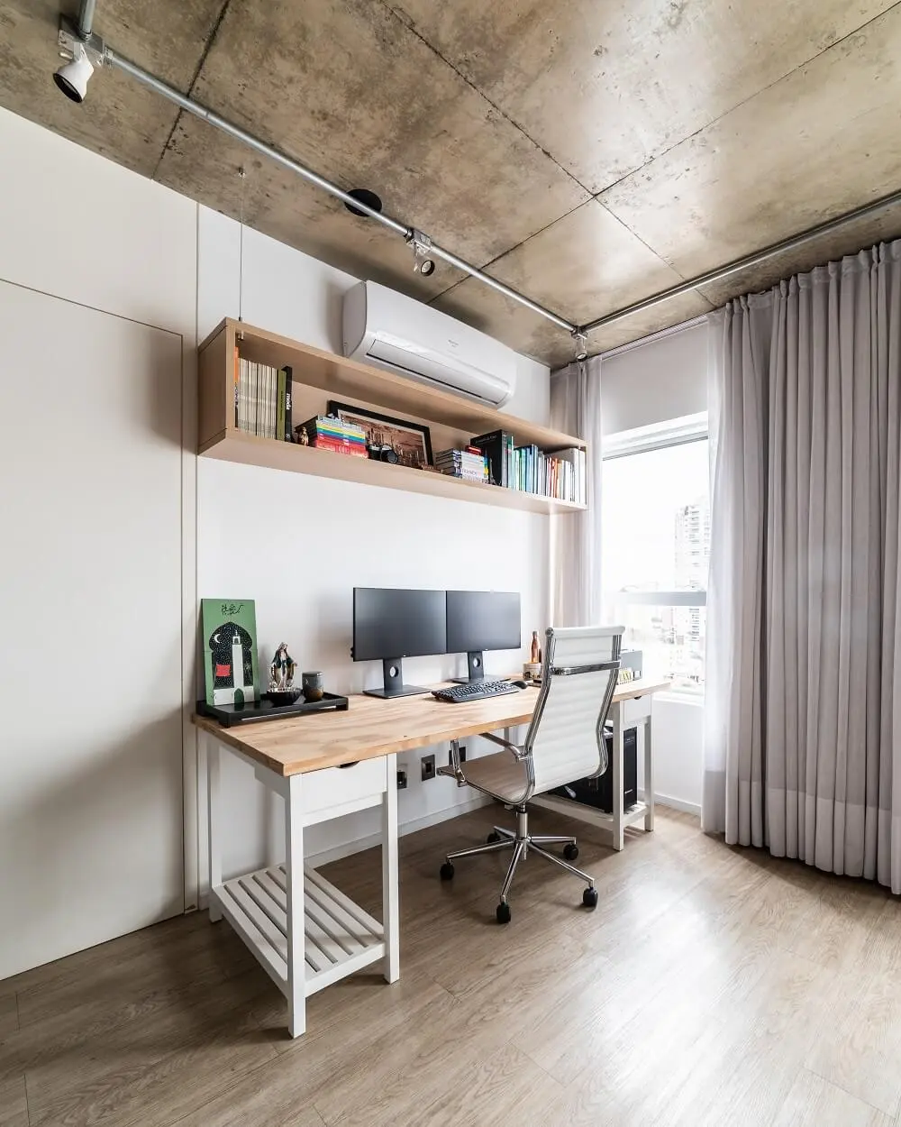 O home office conta com escrivaninha de madeira, nicho aéreo e cadeira confortável. Foto: Guilherme Pucci