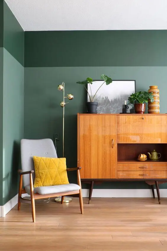 Quarto boho com parede verde e móveis de madeira