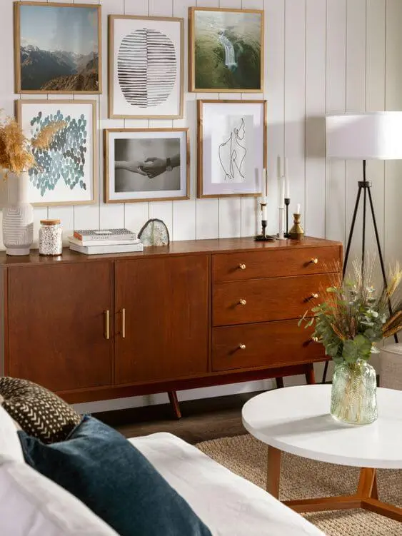 Rack rustico de madeira na sala de estar com quadros e móveis confortáveis
