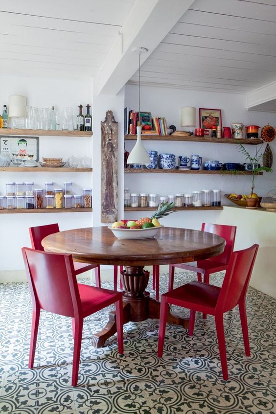 Sala de jantar com mesa de madeira e cadeira vermelha