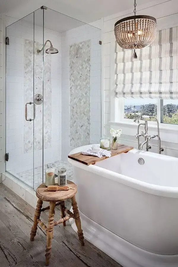banheiro com banheira decorado com piso rústico e lustre de teto Foto OneChitecture