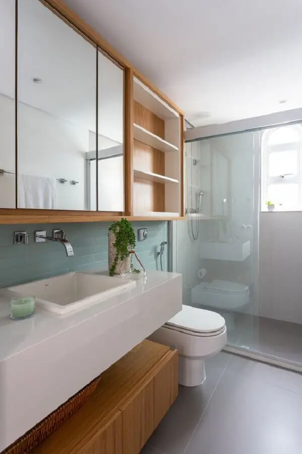 banheiro decorado com armário suspenso de madeira com prateleiras brancas Foto Rúbia M. Vieira Interiores