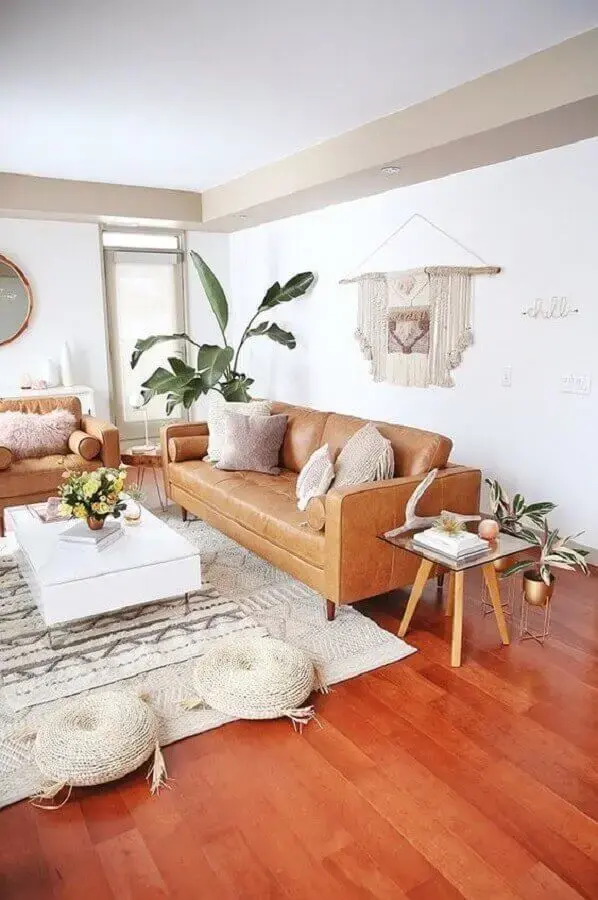 Decoração de sala de estar com sofá de couro caramelo e tapete bege