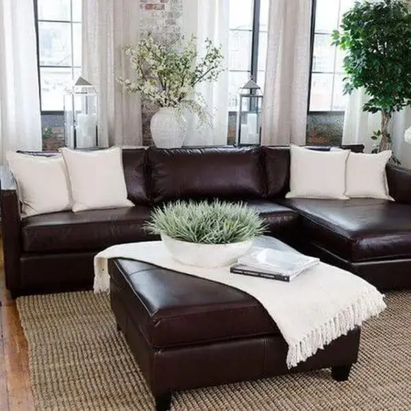 Decoração com sofá marrom escuro e decoração branca em contraste