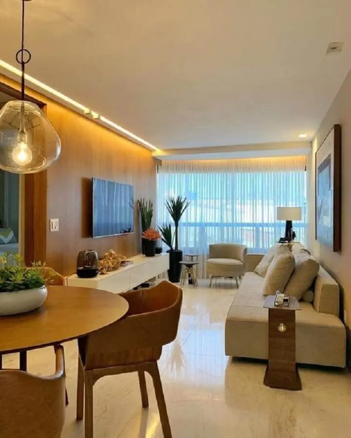 decoração de sala de apartamento em cores neutras com painel de madeira para TV Foto Iluminim LED