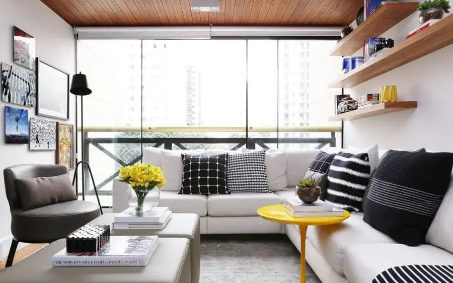 sala de estar apartamento decorado com sofá de canto branco e prateleiras de madeira Foto Now Arquitetura e Interiores