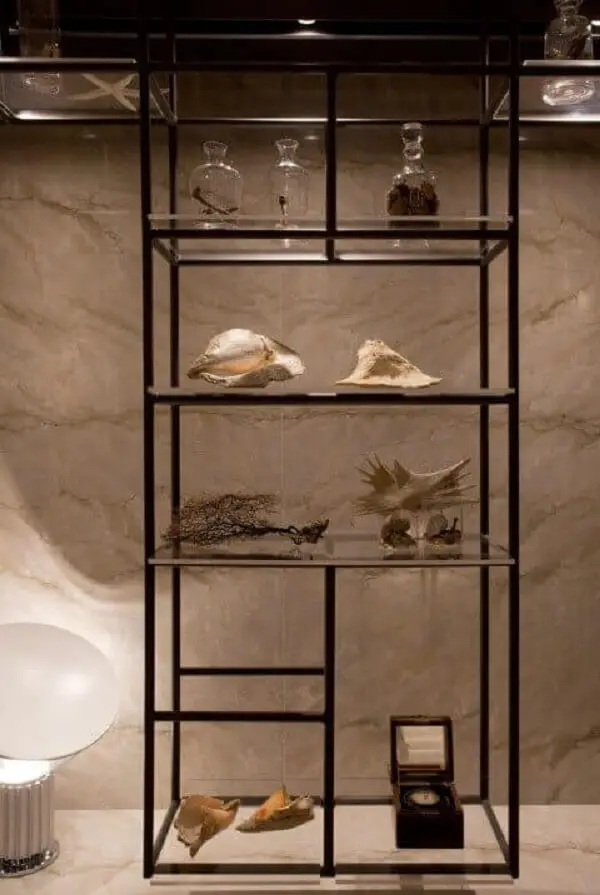 A estante de vidro pode ser usada em diferentes cômodos do imóvel. Projeto de Sandra Moura