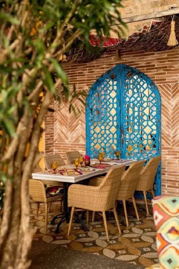 A porta vazada em azul turquesa reforça a decoração indiana na área externa. Fonte: Pinterest