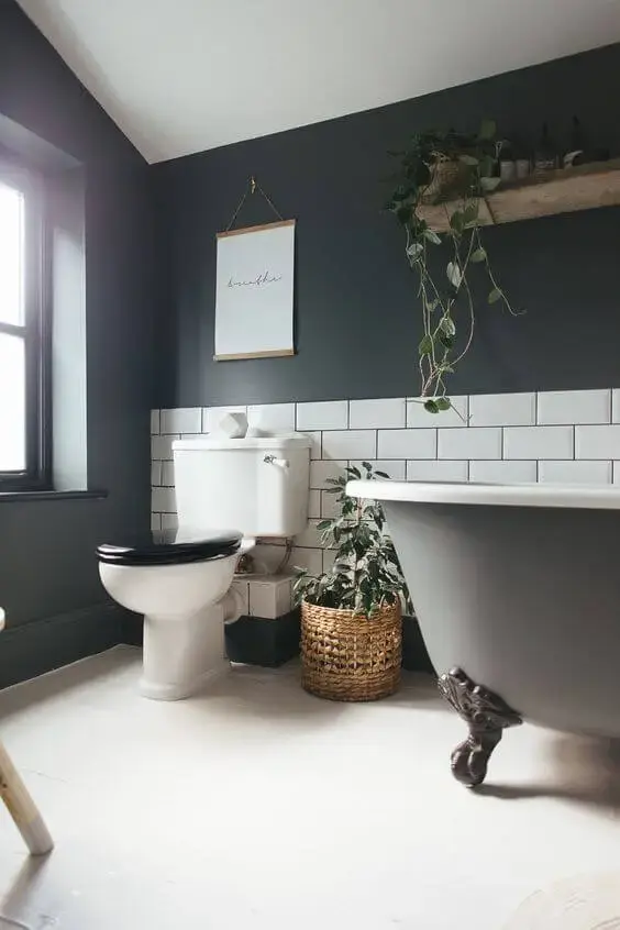 Banheira de pé cinza escuro com tijolinho branco na decoração