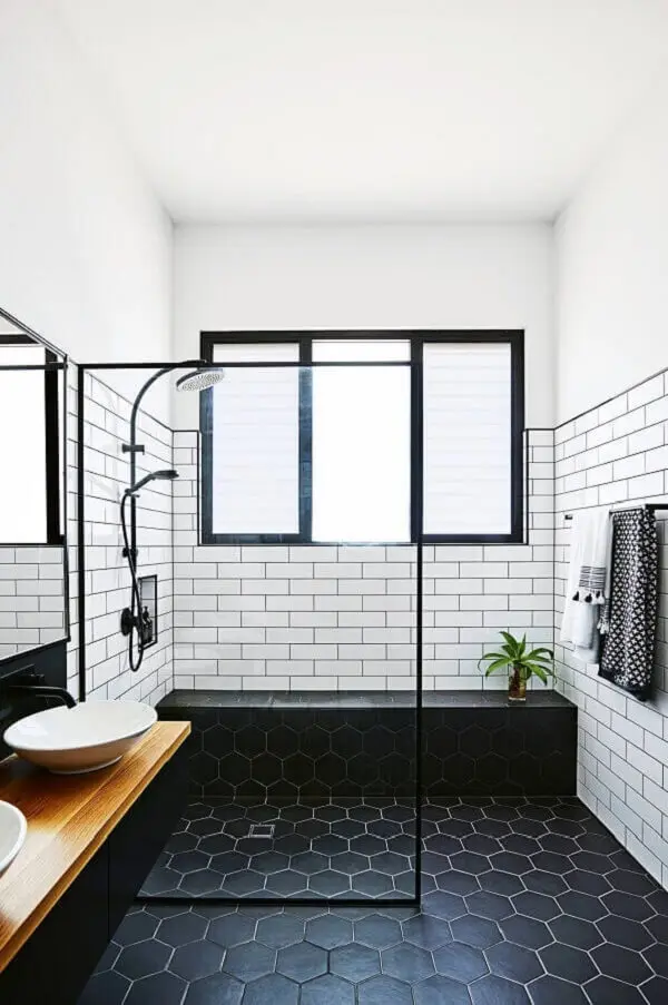 Banheiro minimalista com piso preto hexagonal e revestimento cerâmico branco. Fonte: Pinterest