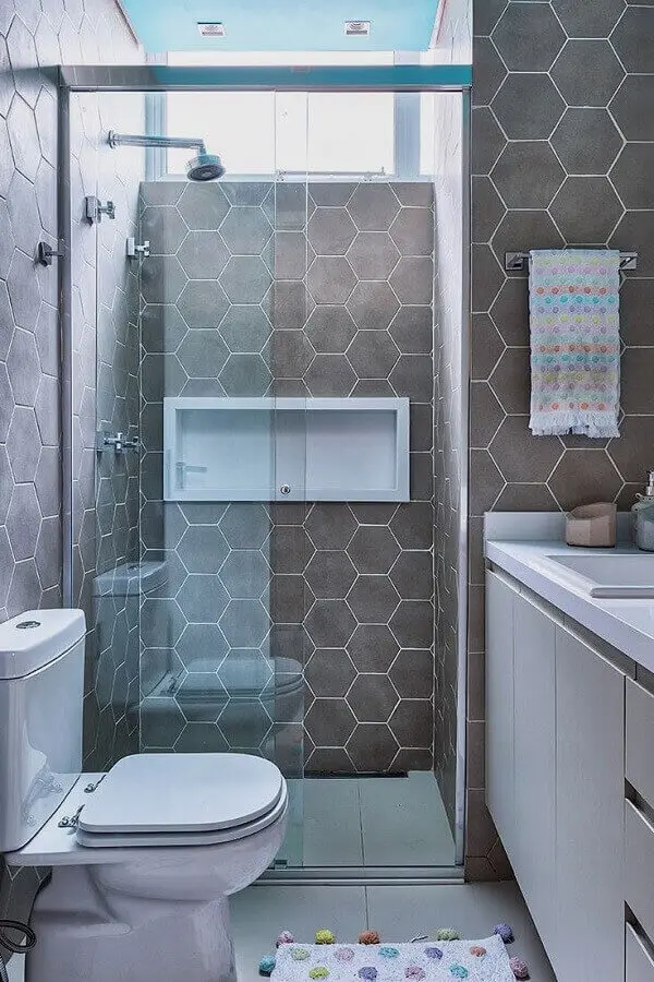 Banheiro pequeno decorado com revestimento cerâmico cinza em formato hexagonal. Fonte: Casa de Valentina