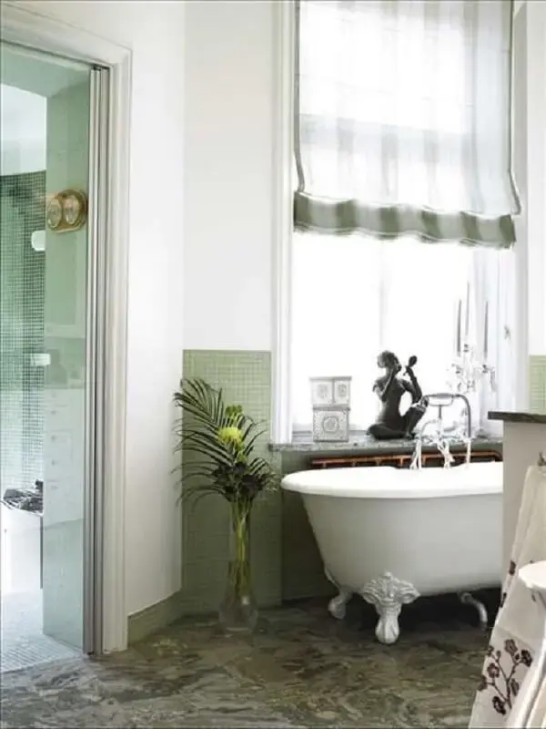 Banheiro verde com banheira de pé branca