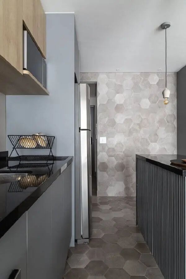 Cozinha moderna com revestimento cerâmico cinza que se estende do piso para a parede. Fonte: MSAC Arquitetura