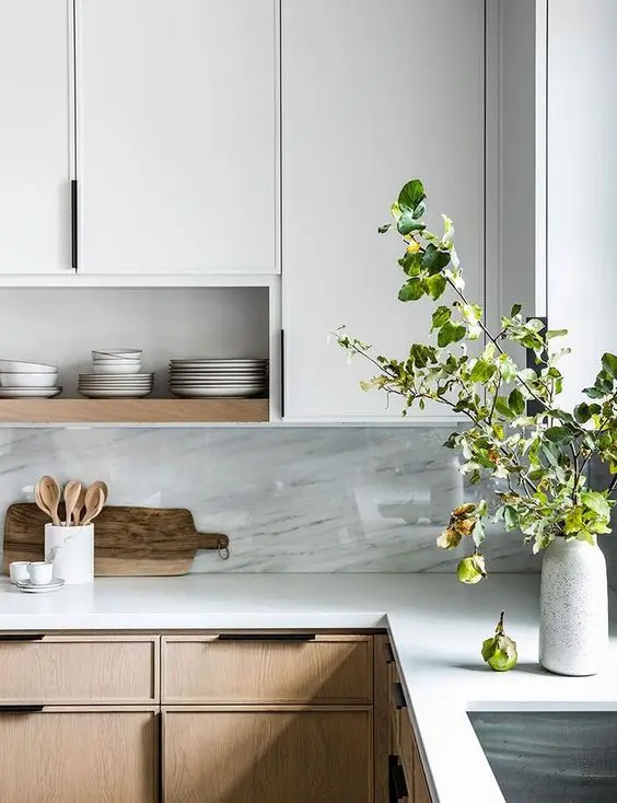 Cozinha moderna em L com silestone branco na bancada e decoração com plantas