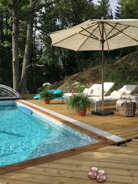 Guarda sol para piscina com espreguiçadeira e deck de madeira moderno