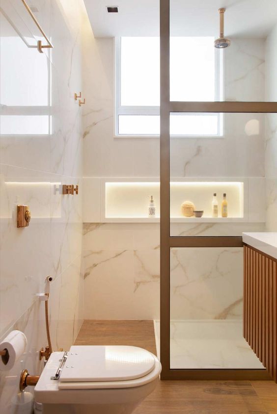 Revestimento marmorizado no banheiro com moveis de madeira e nicho de embutir branco
