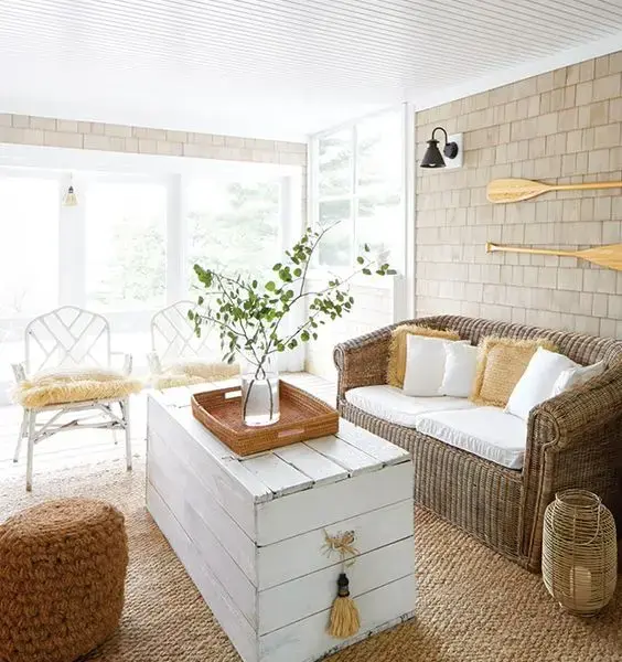 Sala com baú de madeira branca e decoração rústica