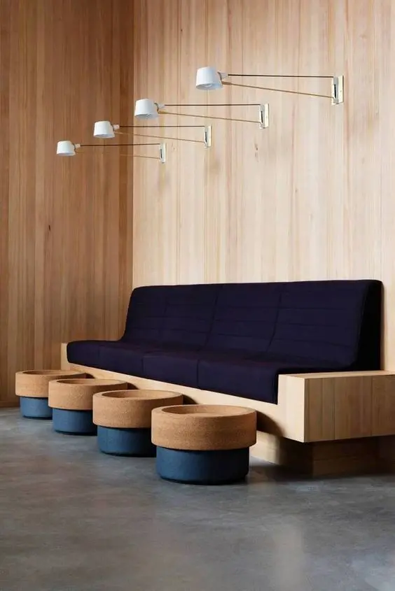 Sala de espera com sofá azul marinho e estrutura de madeira
