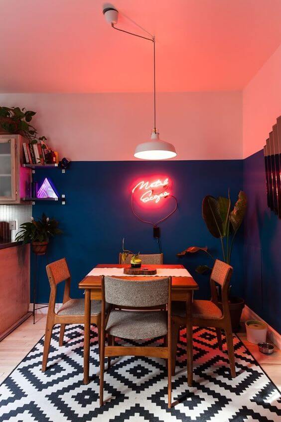 Sala de jantar com parede na cor coral e azul marinho