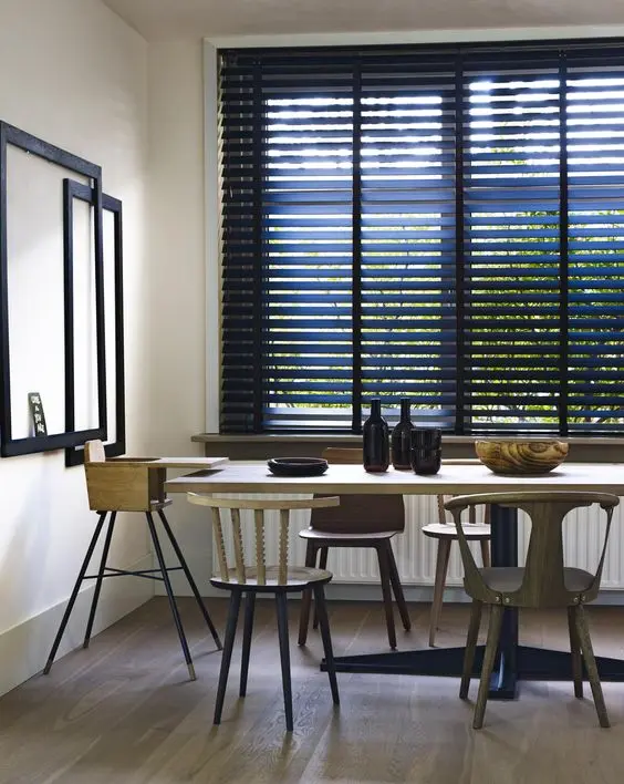 Sala de jantar com persiana preta e móveis de madeira