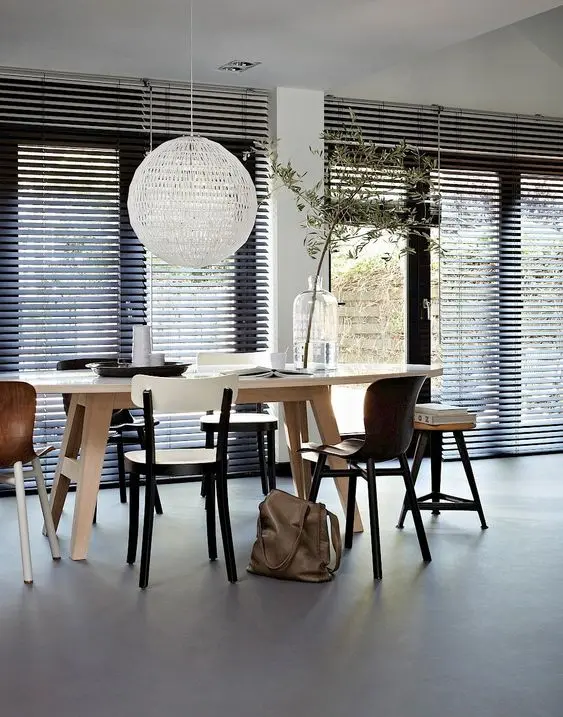 Sala de jantar com persiana preta e móveis de madeira modernos