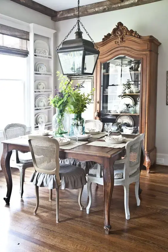 Sala de jantar rústica com mesa provençal e cristaleira de madeira