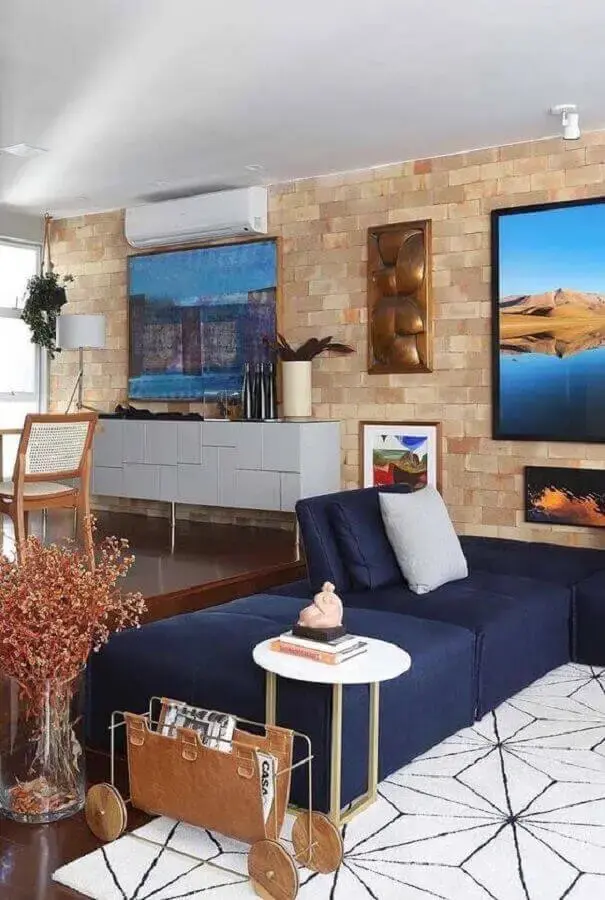 Sala moderna com sofá azul marinho e parede de tijolinho