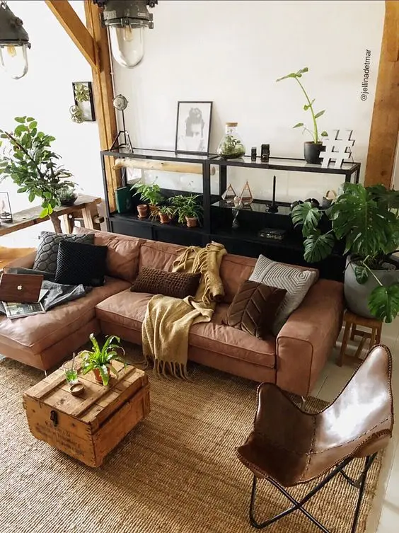 Sofá estilo industrial marrom na sala decorada com plantas