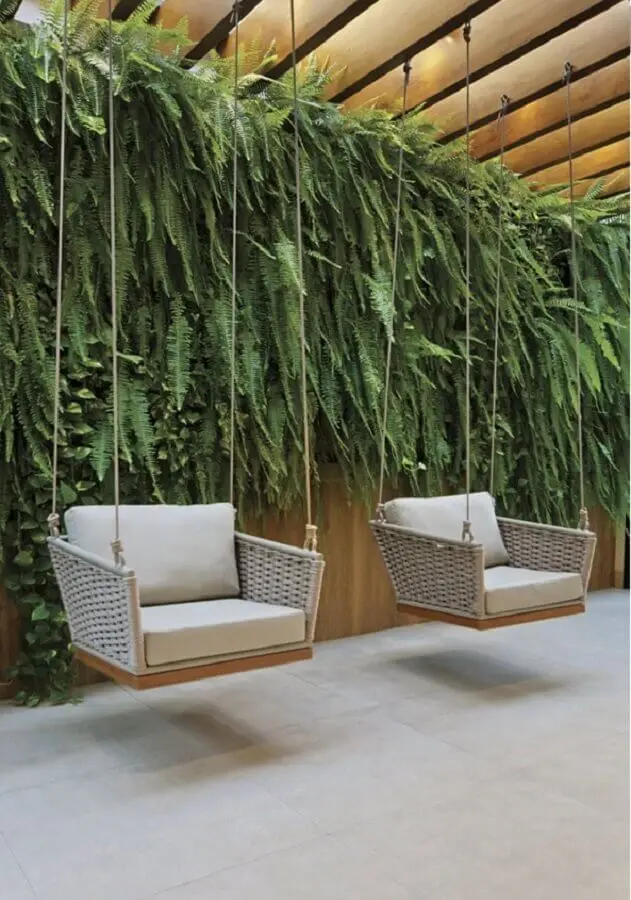 cadeira de balanço moderna suspensa para decoração de varanda com jardim vertical Foto Revista InterArq
