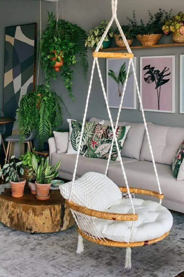 cadeira de balanço suspensa para sala cinza decorada com vasos de plantas e mesa de centro rústica Foto Pinterest