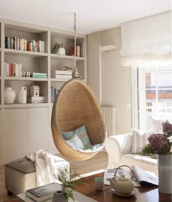 Cadeira de balanço suspensa para sala de estar decorada em cores neutras  Foto El Mueble